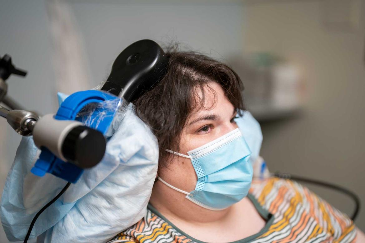 photo of a woman with a blue surgical mask with a medical device resting on her head