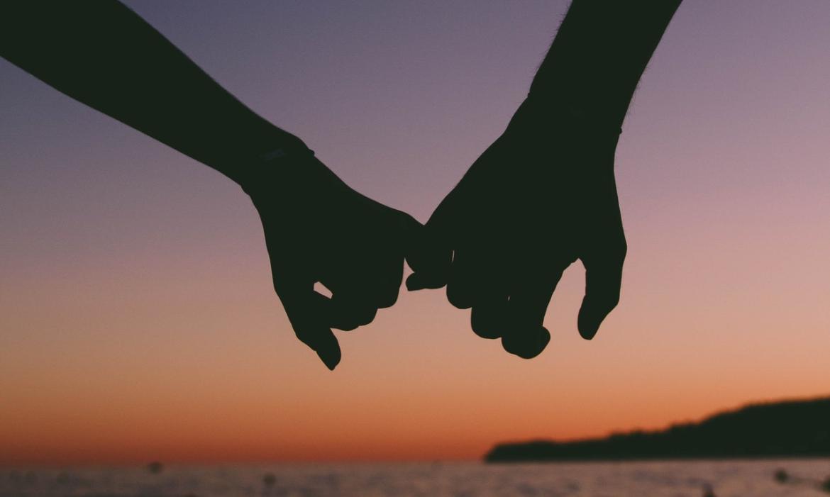Silhouette of a couple's joined hands 