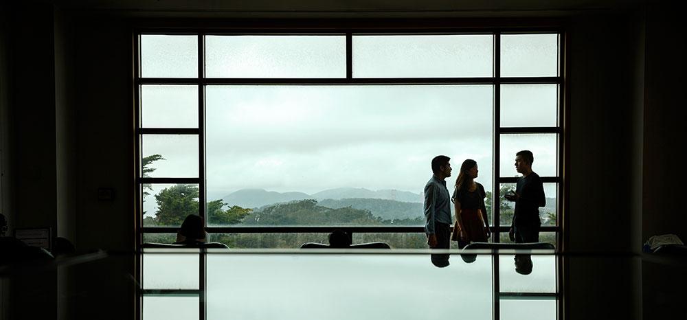 People talking in front of a window