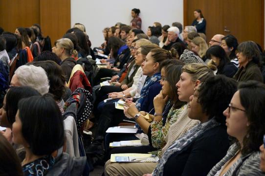 Audience members listening to a presentation