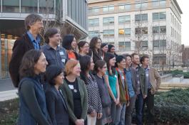 Current and former members of the Doupe Lab stand in front of the Sanders Neurosciences Building on the UCSF Mission Bay campus. 