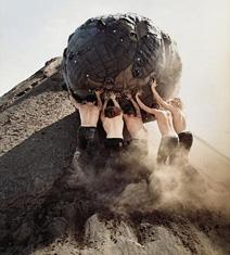 People pushing a rock up a hill