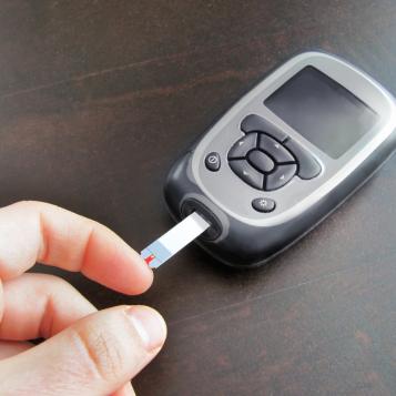 A person testing their blood glucose level