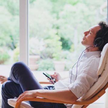 Person sitting in a chair and listening to headphones